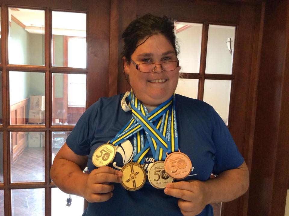 Une athlète spéciale soulève quatre médailles