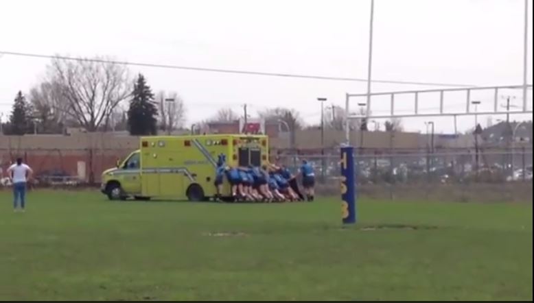 Rugby players push an ambulance